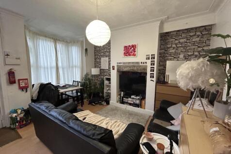 A spacious and cozy living room with ample natu...