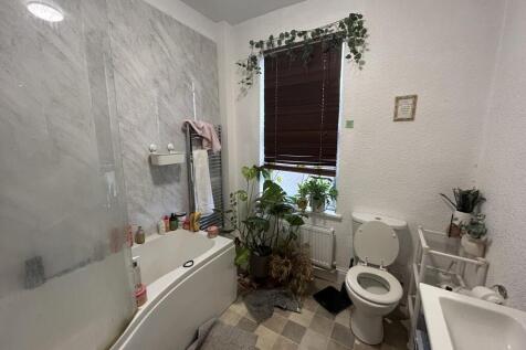 Bright and clean bathroom with a bathtub, toile...