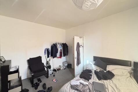 A cozy bedroom featuring a neatly made double b...