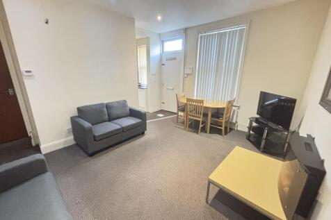 A spacious and well-lit living room featuring c...