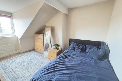 A cozy bedroom featuring a neatly made double b...