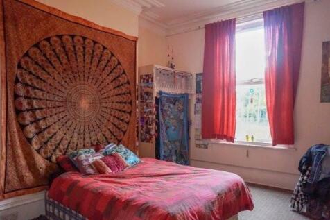 A cozy bedroom featuring a large bed with color...