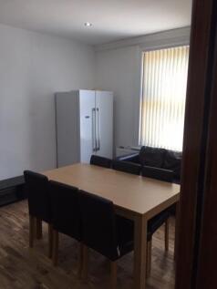 A bright communal lounge featuring a large wind...