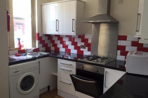 A modern kitchen featuring white cabinets, a ga...