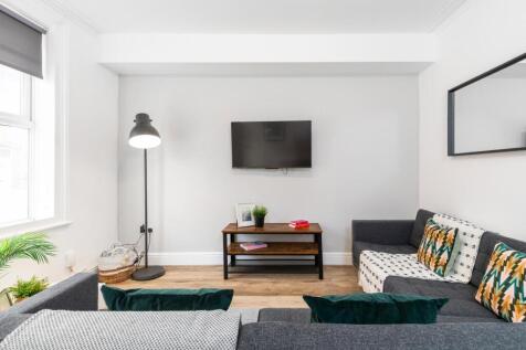 Bright, modern living room with comfortable sea...