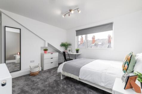 Bright, neatly furnished bedroom with a double ...