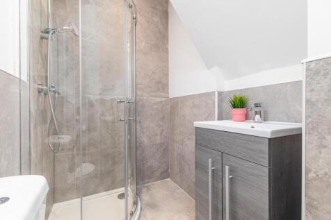Modern bathroom with a corner glass shower encl...