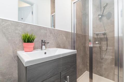 Modern ensuite-style bathroom with a glass show...