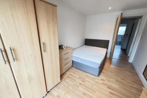 A clean and bright bedroom featuring a comforta...