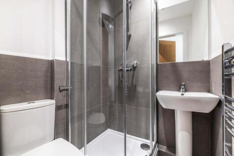 A clean and modern bathroom featuring a shower,...