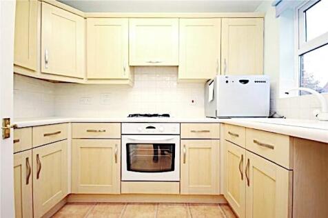 Bright, modern kitchen with light wood cabinetr...