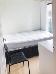 Bright, simply furnished bedroom with a comfort...