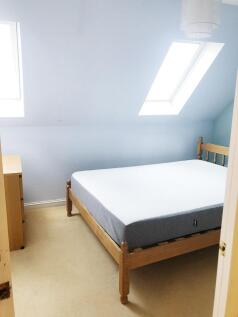 Bright double bedroom in a loft room with two s...