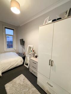 A bright and well-maintained bedroom featuring ...