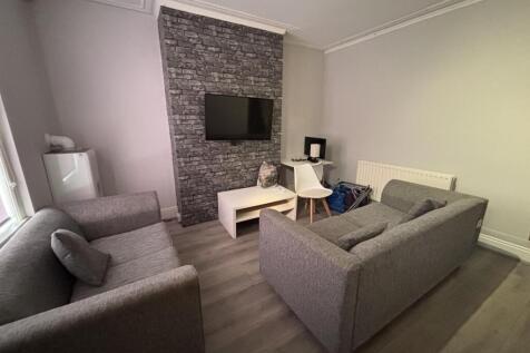 A modern, well-lit living room featuring two co...