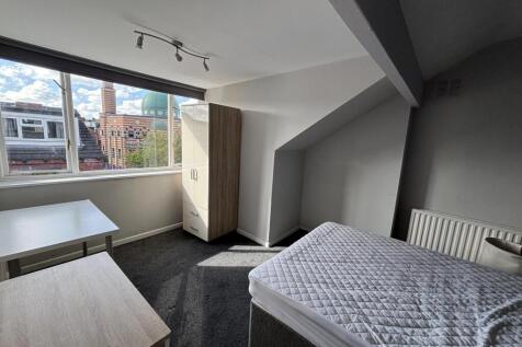 A well-lit, clean bedroom featuring a double be...