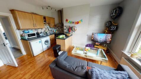 A well-lit, tidy living room featuring a comfor...