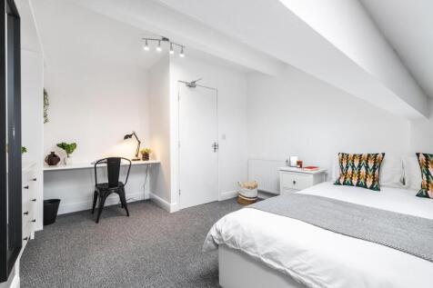 A bright, neatly presented bedroom featuring a ...