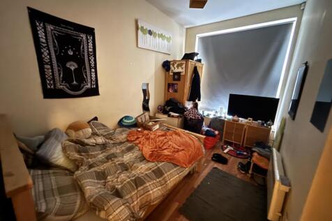 A cozy bedroom featuring a large bed, personal ...