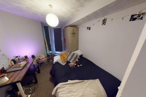 A cozy student bedroom featuring a single bed, ...