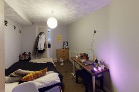 A cozy bedroom featuring a double bed with pill...