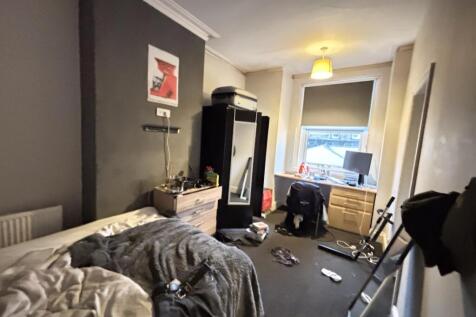 A cozy bedroom featuring a double bed, a desk a...