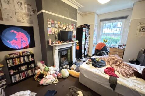 A cozy bedroom featuring a large bed with a var...