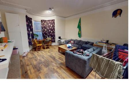 A spacious, well-lit living room with a large s...