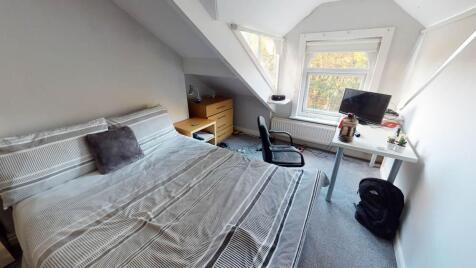 A bright and cozy bedroom featuring a double be...