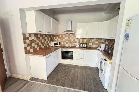 Bright, modern kitchen with white cabinets, int...