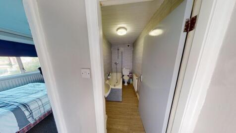 A bright and clean bathroom with a large bathtu...