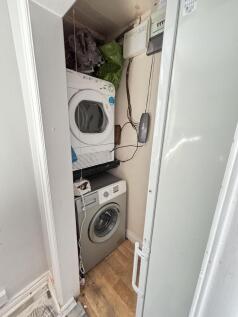 A compact laundry area with a washing machine s...