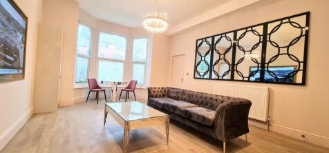 Bright and spacious living room featuring large...