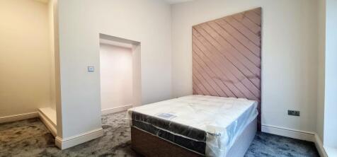 A spacious and well-lit master bedroom featurin...