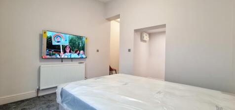 A bright and tidy single bedroom featuring a co...