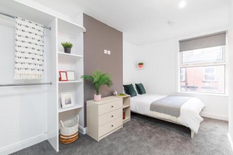 Bright, modern master bedroom with a comfortabl...