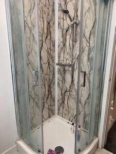 A modern enclosed shower unit with clear glass ...