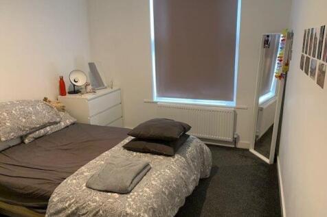 A well-lit double bedroom featuring a comfortab...