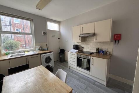 A bright and tidy kitchen with ample natural li...