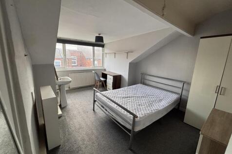 A bright and tidy bedroom featuring a comfortab...