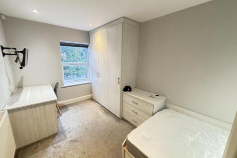 A well-maintained bedroom with a single bed, a ...