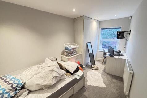 A cozy bedroom with a single bed, a desk, and a...