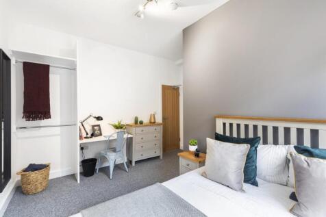 Bright, neatly styled double bedroom with a com...