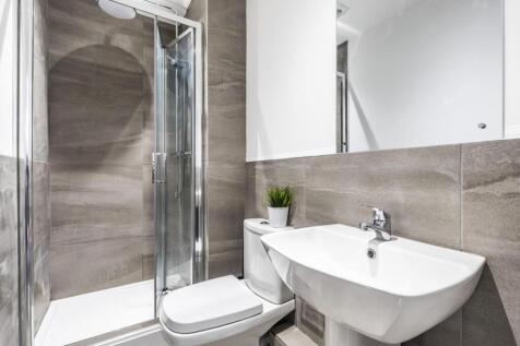 Modern ensuite-style bathroom featuring a glass...