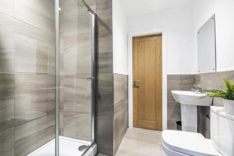 Bright modern bathroom with a walk-in glass sho...