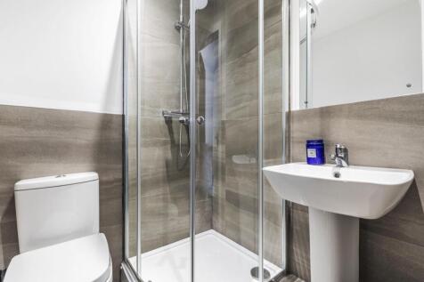Modern ensuite-style bathroom with a glass-encl...