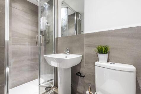 Bright, modern bathroom with a glass shower enc...