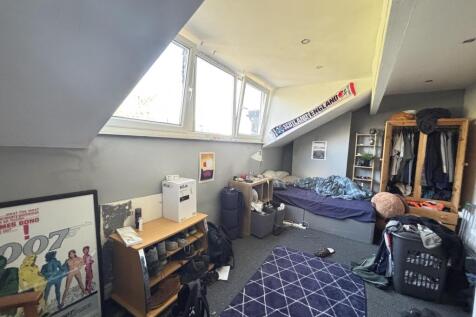 A cozy student bedroom with a large window prov...