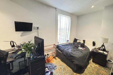 A cozy bedroom featuring a double bed, desk, an...