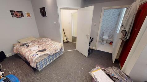 A modest bedroom featuring a single bed, some s...